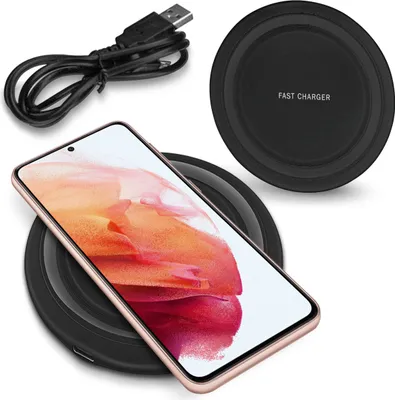 A smartphone is placed on a wireless charging pad, with a USB cable nearby.