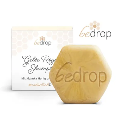A hexagonal solid shampoo bar and its packaging are displayed against a white background.
