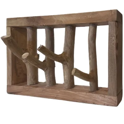 A wooden coat rack with branches as hooks, mounted on a white background.