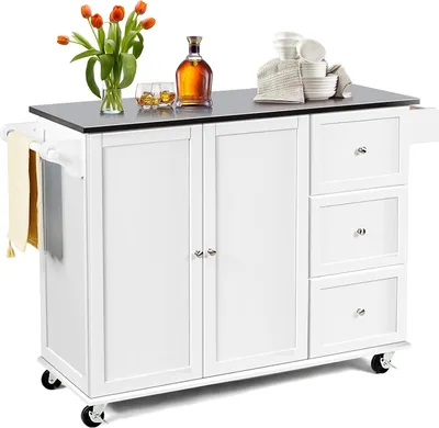 A white kitchen island with a black countertop, featuring cabinets, drawers, and a towel rack. Decorative items like flowers, bottles, and bowls are placed on the countertop.