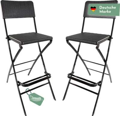 Two black folding bar stools with a rattan-look seat and backrest are shown against a white background. A green tag with the text "Lemodo" is attached to the left stool, and a green banner with the German flag and the text "Deutsche Marke" is on the backre