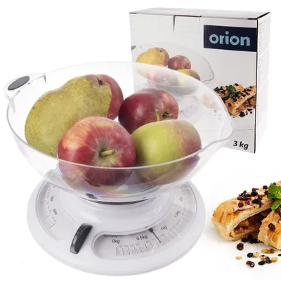 A kitchen scale with a clear bowl filled with apples and a pear, placed next to its packaging.
