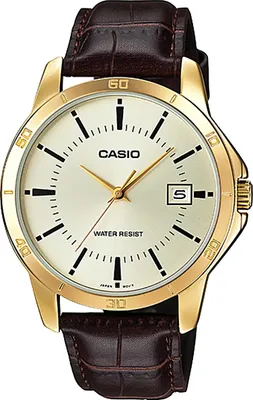 A close-up studio shot of a gold-colored Casio watch with a brown leather strap.
