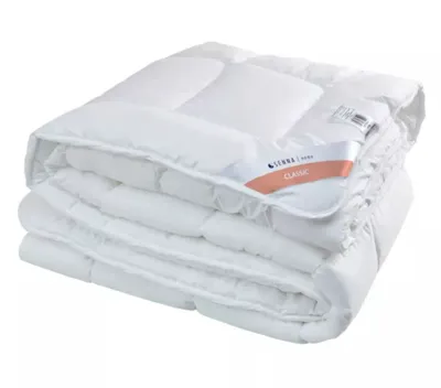 A folded white comforter is shown against a white background.