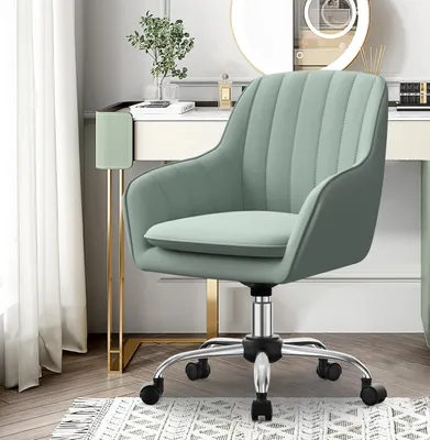 A light green office chair with a silver base and wheels is shown in a room with a vanity table and a window with white curtains.