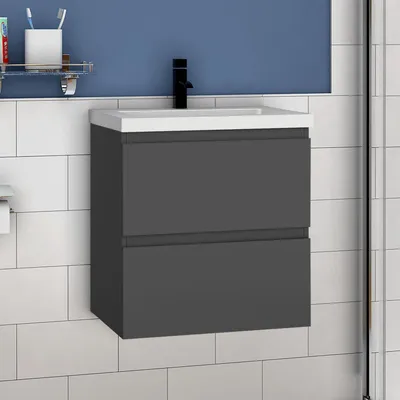 A bathroom vanity with a sink and faucet against a tiled wall and blue background.