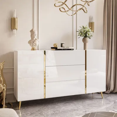 A modern white dresser with gold accents and legs, decorated with a bust and flowers.