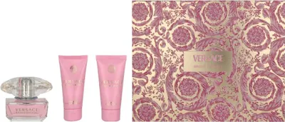 A Versace Bright Crystal EDT gift set including a perfume bottle and two lotions, alongside a decorative gift box.