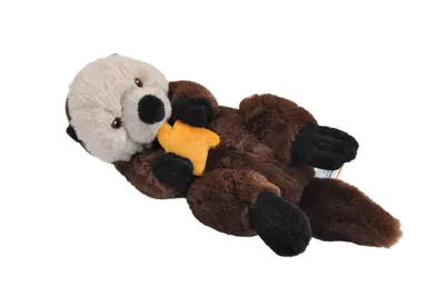 A plush toy sea otter holding a yellow star, lying on its back against a white background.