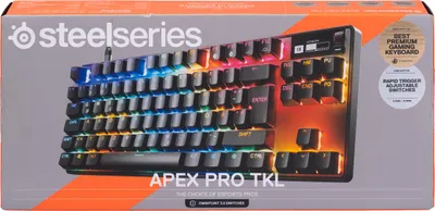 The image shows the packaging of a SteelSeries Apex Pro TKL gaming keyboard. The keyboard itself is visible on the box, with its RGB lighting illuminated.