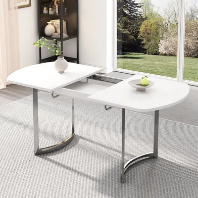 A white dining table with silver metal legs is shown in a well-lit room with a large window overlooking a garden.