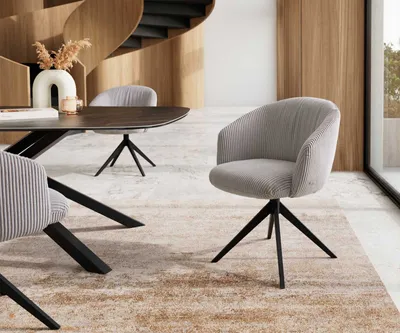 A modern dining room setting with a table and chairs.