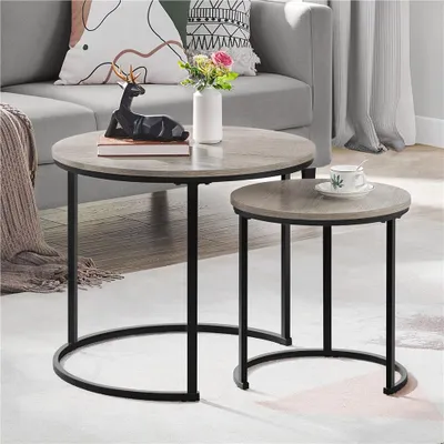 A living room setting with two nesting coffee tables, a sofa, and decorative items.