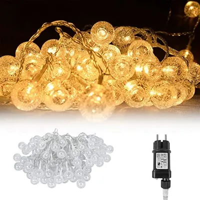 A string of warm white LED fairy lights with clear, textured globe bulbs, shown both illuminated and unlit, alongside a power adapter.