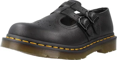 A black Dr. Martens Mary Jane shoe with buckles and yellow stitching is shown from a side angle against a white background.