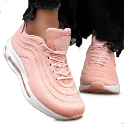 A pair of pink sneakers worn by a person, shown from a slightly elevated angle.