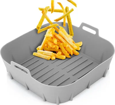 A gray silicone air fryer insert filled with french fries, with more fries falling from above.