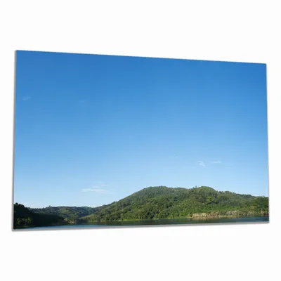 Produktbild von Wallario Herdabdeckplatte aus Glas, Größe 80 x 52 cm 1-teilig, Motiv Grüne Hügel am Wasser