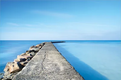Produktbild von Wallario Premium Vliestapete Fototapete Pier am blauen Ozean mit blauem Himmel in der Größe 400 x 267 cm, extra dick, wird in 5 Teilen geliefert