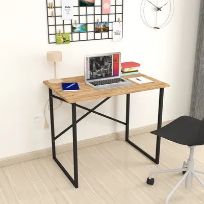 A small desk with a laptop, lamp, and books.