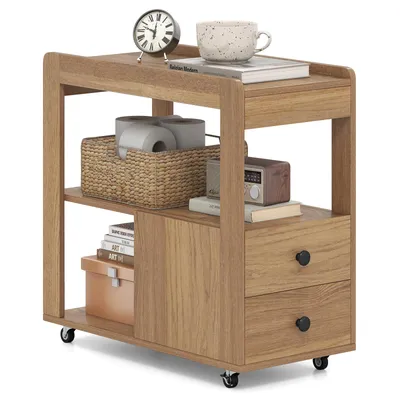 A wooden side table with two drawers and open shelves, displaying various items like books, toilet paper, a clock, and a mug.