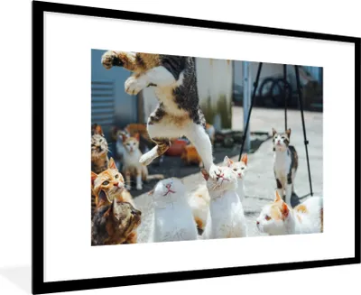 Produktbild von MuchoWow® MuchoWow® Gerahmtes Poster Komische Katze, die über andere Katzen springt 90x60 cm - Poster mit zchwarzem Bilderrahmen - Wanddekoration - Fotos