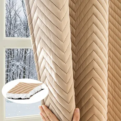 A hand is holding a beige quilted curtain, revealing a snowy forest scene through a window behind it. A close-up inset shows the texture of the curtain.