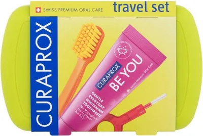 A travel set for oral care, including a toothbrush, toothpaste, and interdental brushes, presented in its packaging.