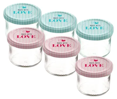 A group of six small glass jars with decorative lids.