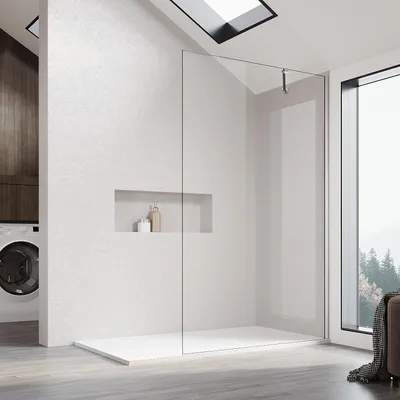 A modern bathroom with a walk-in shower, washing machine, and a large window overlooking a forest.