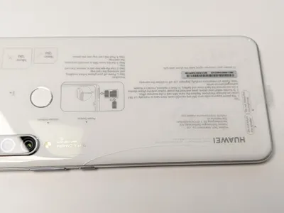 The back of a white Huawei P30 Lite smartphone with instructional text and diagrams.