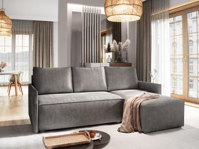 A modern living room with a gray sectional sofa, a coffee table, and large windows.