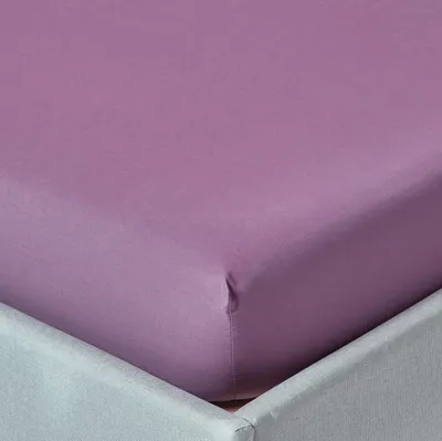 A close-up view of a purple fitted sheet on a bed.