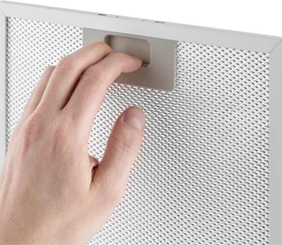 A hand is shown interacting with a metal mesh filter, likely for a kitchen appliance.