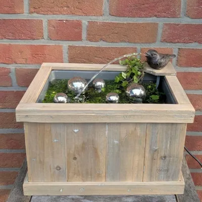 Produktbild von Storm's Gartenzaubereien Miniteich Komplettset mit Wasserspeier Spatz, Holzkiste, 230V Pumpe & 5 Schwimmkugeln, 42x32 cm, KI-generiertes Bild
