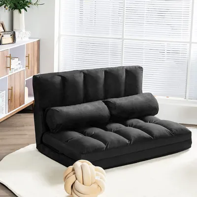 A black sofa bed is shown in a room with a window and a cabinet.