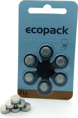 A blister pack of hearing aid batteries with some batteries spilled out in front.