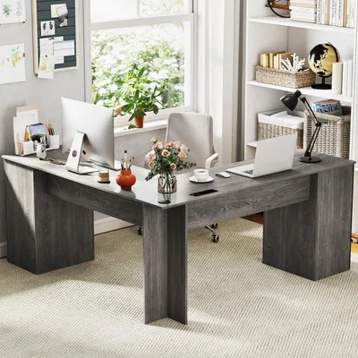 A home office setup with an L-shaped desk, computer, and decorative items.