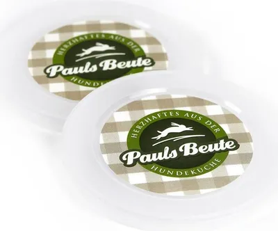 Two white plastic lids with a circular label featuring a checkered pattern and branding.