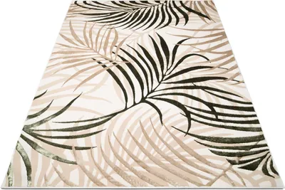 A rug with a palm leaf pattern is shown from a diagonal angle on a white background.