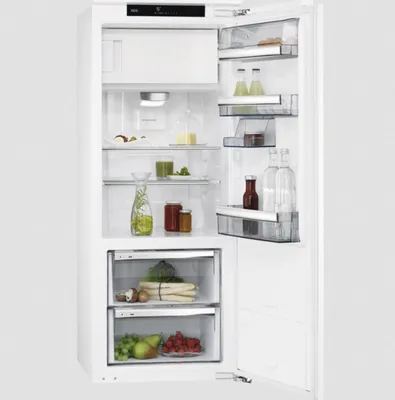 An open built-in refrigerator with food items inside.