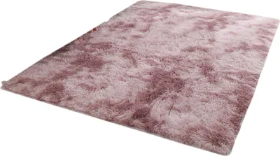A fluffy, shaggy rug with a mottled pink and purple color pattern, shown from a diagonal angle on a white background.