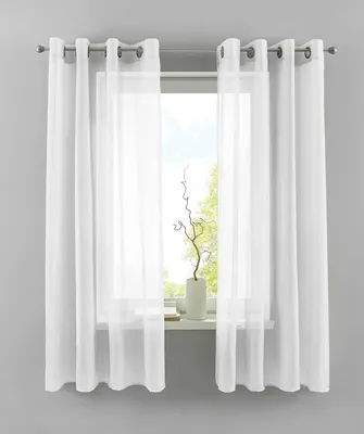A window with white sheer curtains and a decorative branch in a vase on the windowsill.