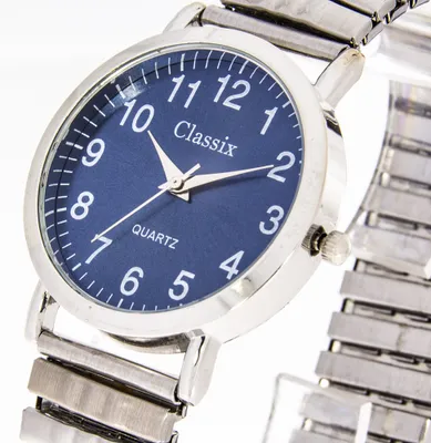A close-up, angled shot of a men's wristwatch with a blue dial and a silver metal expansion band.