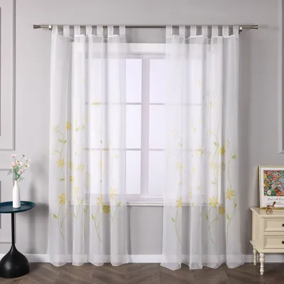 A window with sheer curtains featuring a floral pattern.
