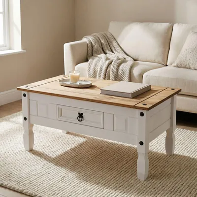 A coffee table in a living room setting, placed on a rug in front of a sofa.