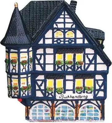 A miniature ceramic building, likely a model or decoration, designed to resemble a traditional half-timbered house with a bookshop sign.
