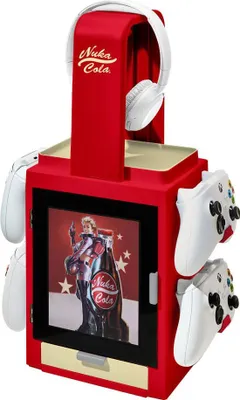A red gaming storage stand with Nuka-Cola branding, holding white controllers and headphones.