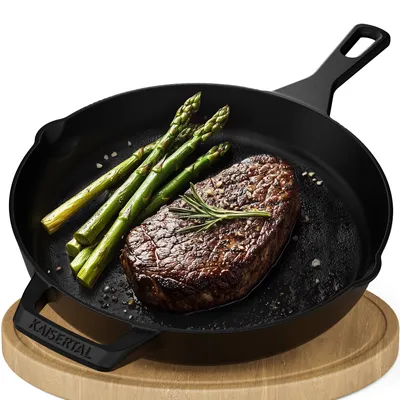 A cast iron skillet with a steak and asparagus on a wooden board.