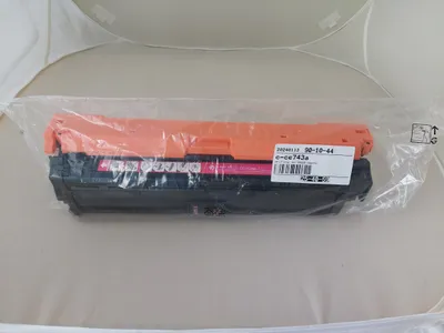 A product sealed in plastic packaging, resting on a light gray surface.